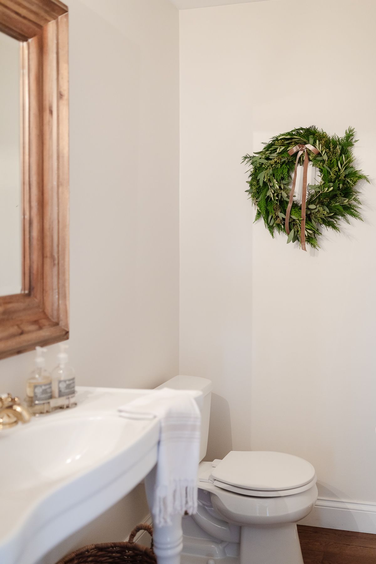 A fresh Christmas wreath in a half bathroom with white walls