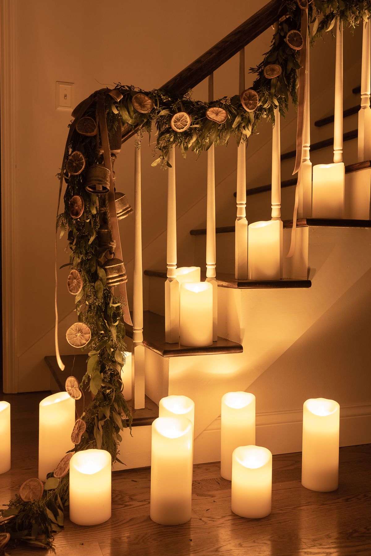 A garland on a staircase with pillar candles all around
