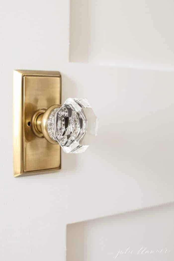 A white wooden door with a classic brass and glass door handle.