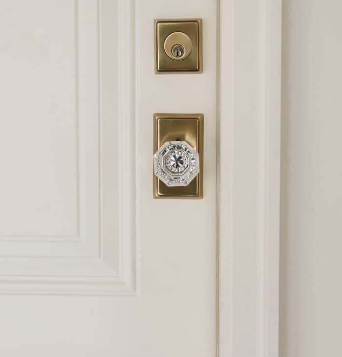 A white wooden door with a classic brass and crystal door knob.