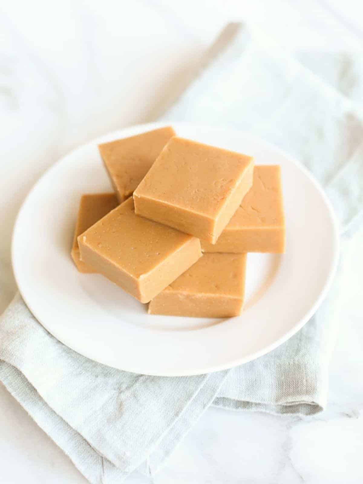 peanut butter fudge on white plate with blue napkin