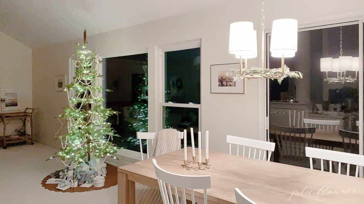 Looking past a kitchen dining room with a sparsely decorated Scandinavian Christmas tree.