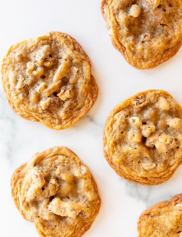 Pecan pie cookies laid out on a white surface.