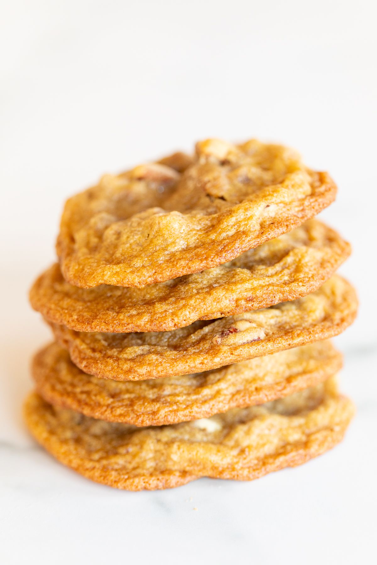 A stack of pecan cookies on a white countertop. 