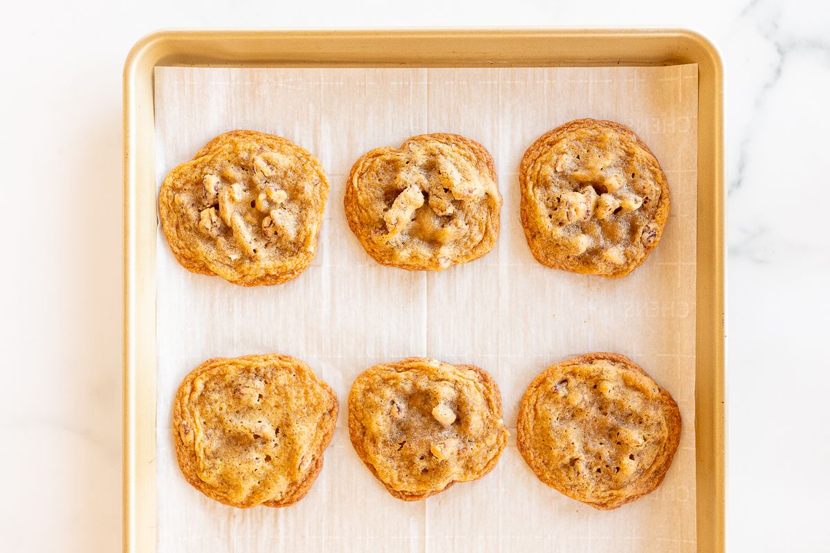 Pecan pie cookies on a parchment lined baking sheet.
