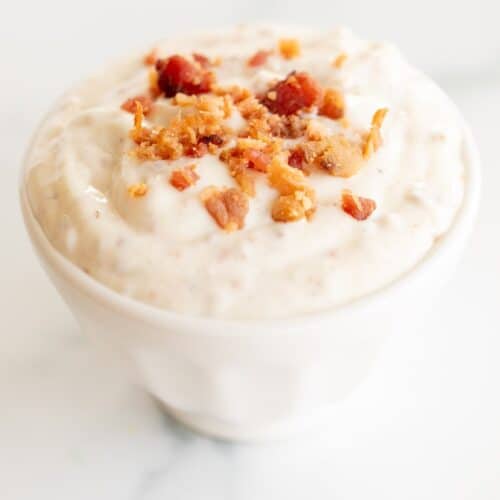Bacon aioli in a small white bowl on a marble surface.