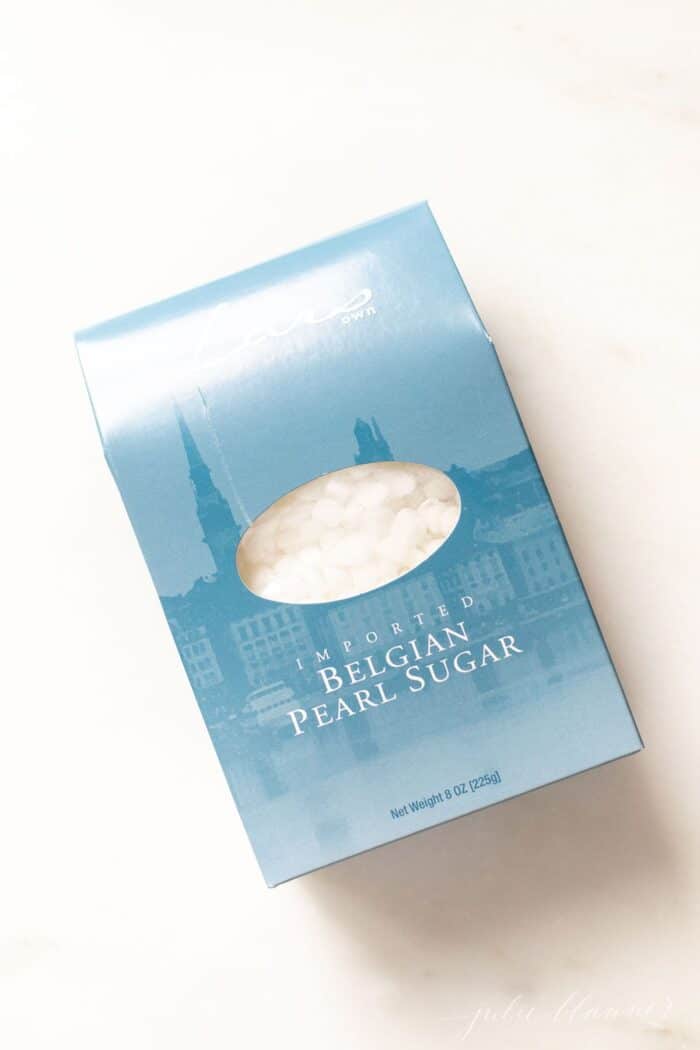 A blue box of Belgian pearl sugar on a white surface.