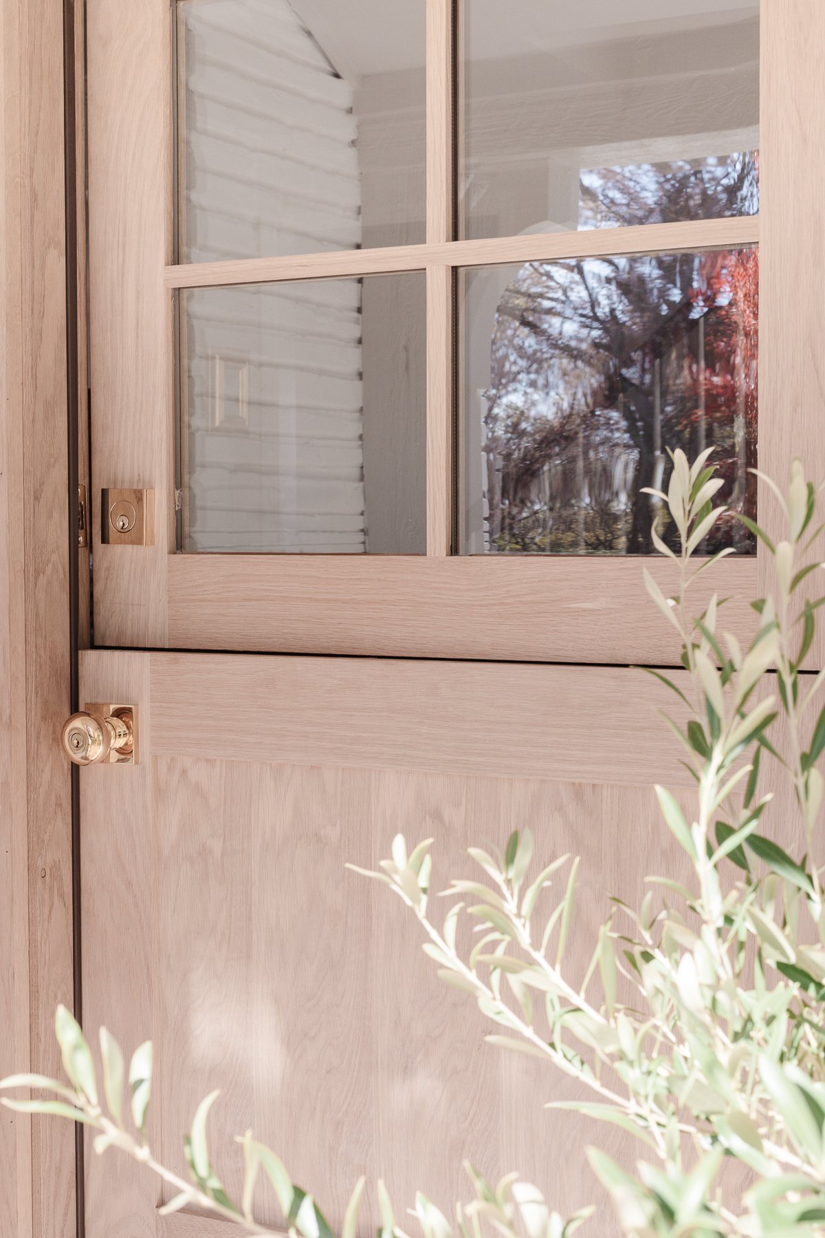 A close up of a wood Dutch door with brass hardware