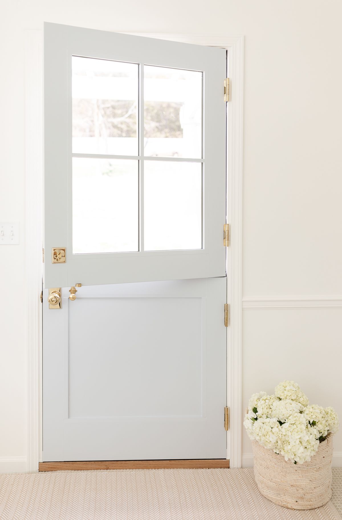 A blue Dutch door with four glass panes on top, looking from the inside out