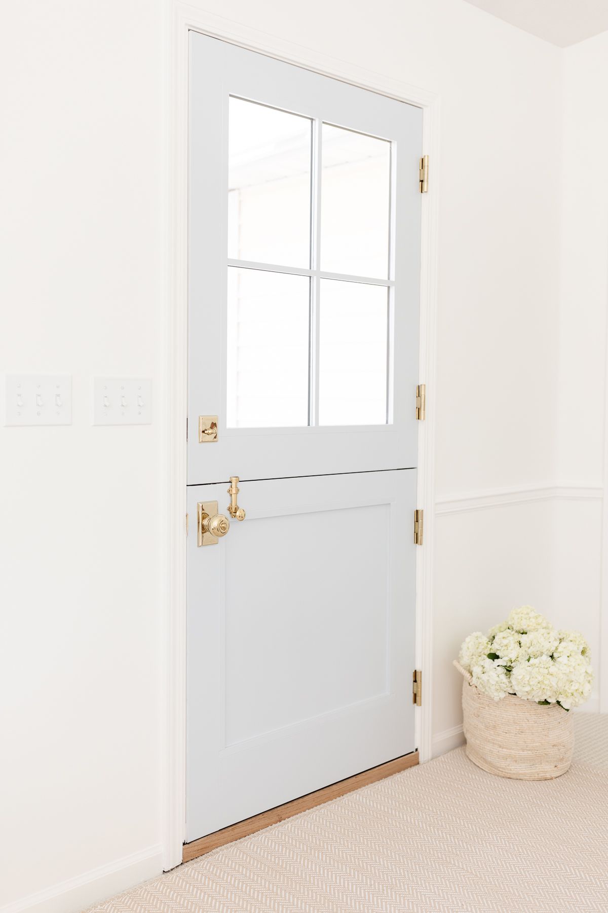 A blue Dutch door with four glass panes on top, looking from the inside out