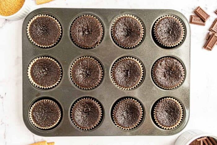 Baked chocolate cupcakes in a cupcake pan.