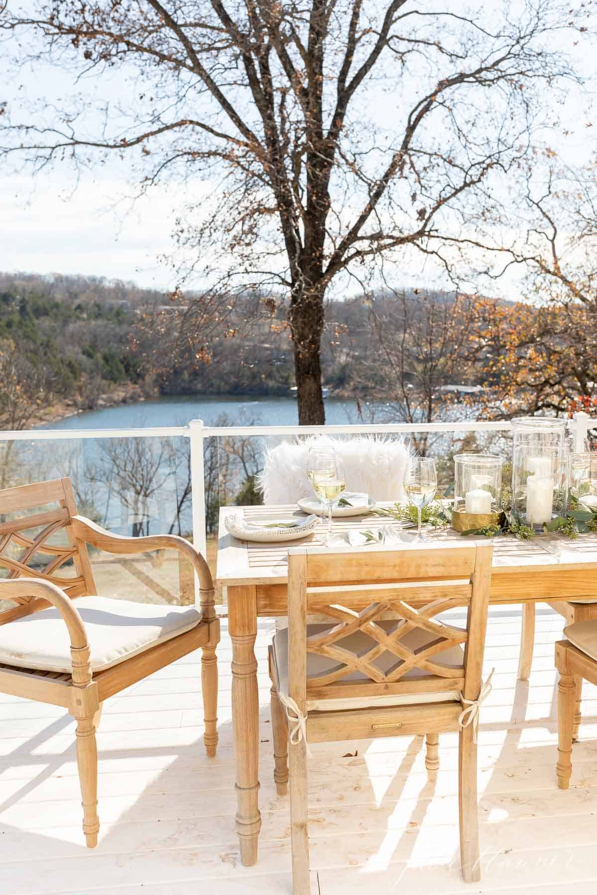 deck with glass deck railing and teak furniture