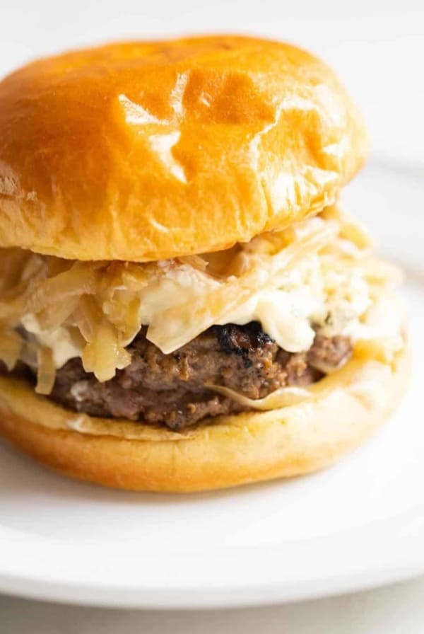 juicy burger on a brioche bun topped with aioli caramelized onion and boursin
