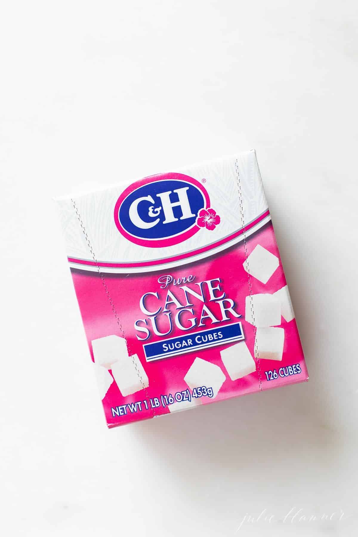A box of cane sugar cubes on a white surface.