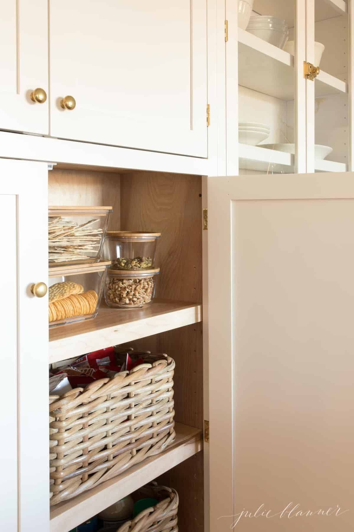 Inset kitchen cabinets with the doors open and pantry goods inside.