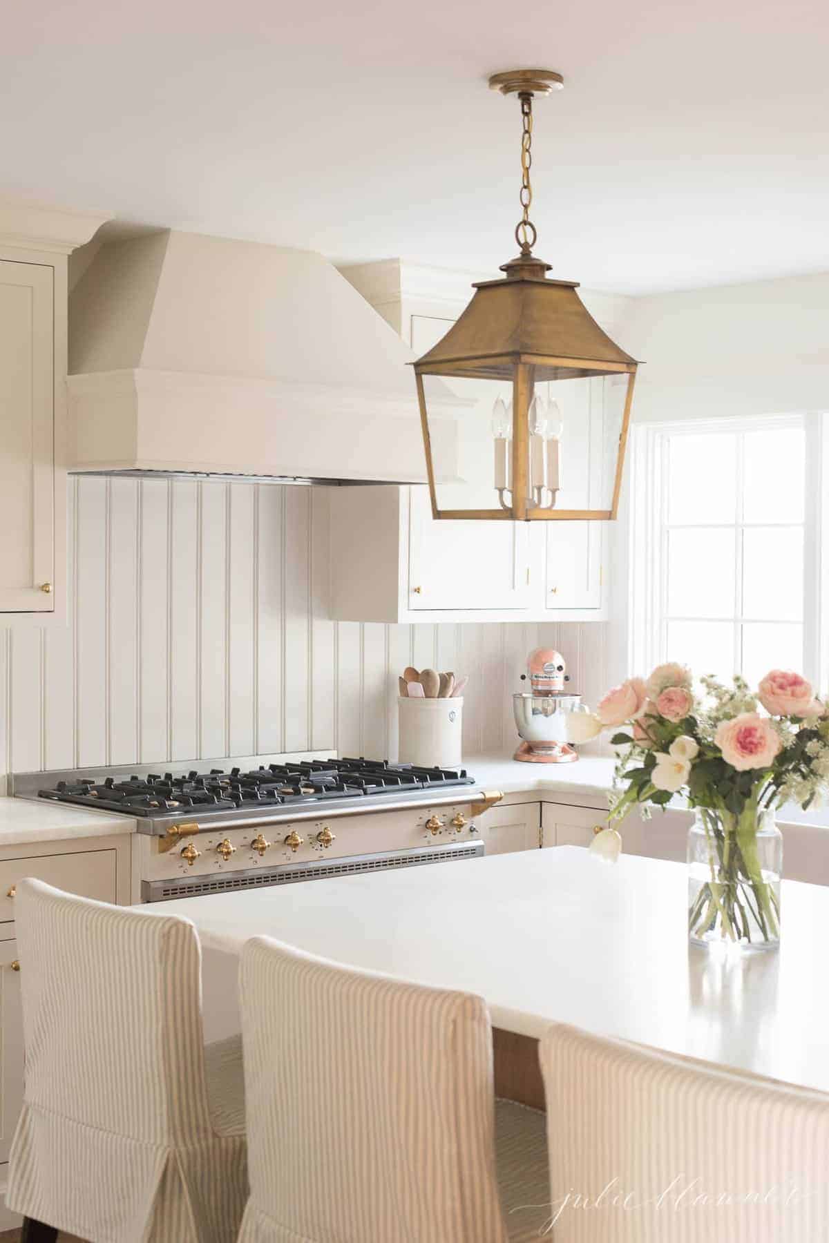 A cream kitchen with a french range and inset cabinets.