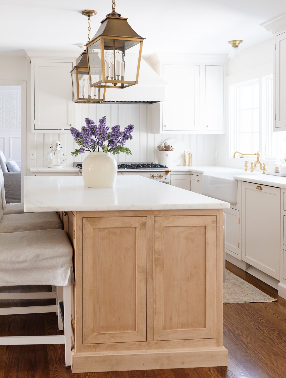 A cream kitchen with inset cabinets and a wood island.
