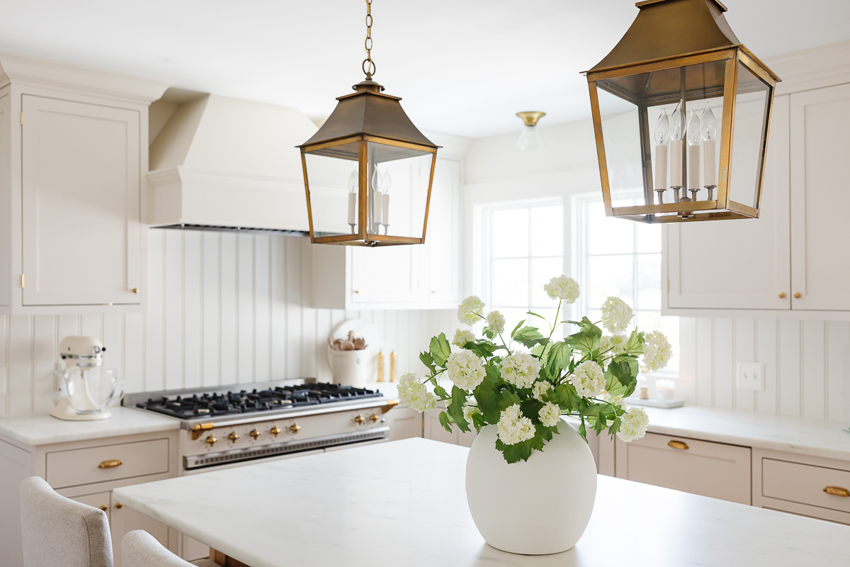 A cream kitchen with inset cabinets and a wood island.