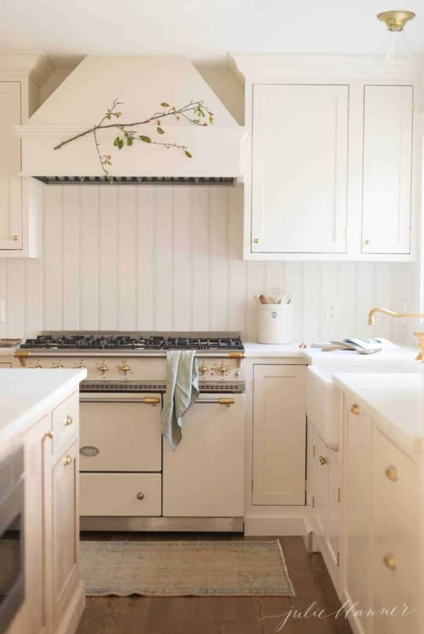 A cream classic kitchen with a french range and inset cabinets.
