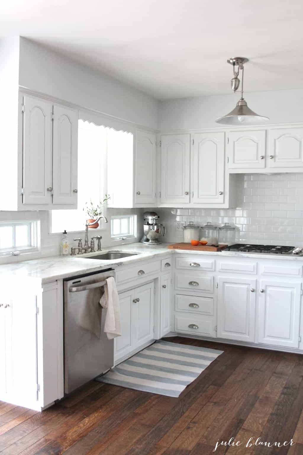 A white kitchen with white subway tile backsplash.