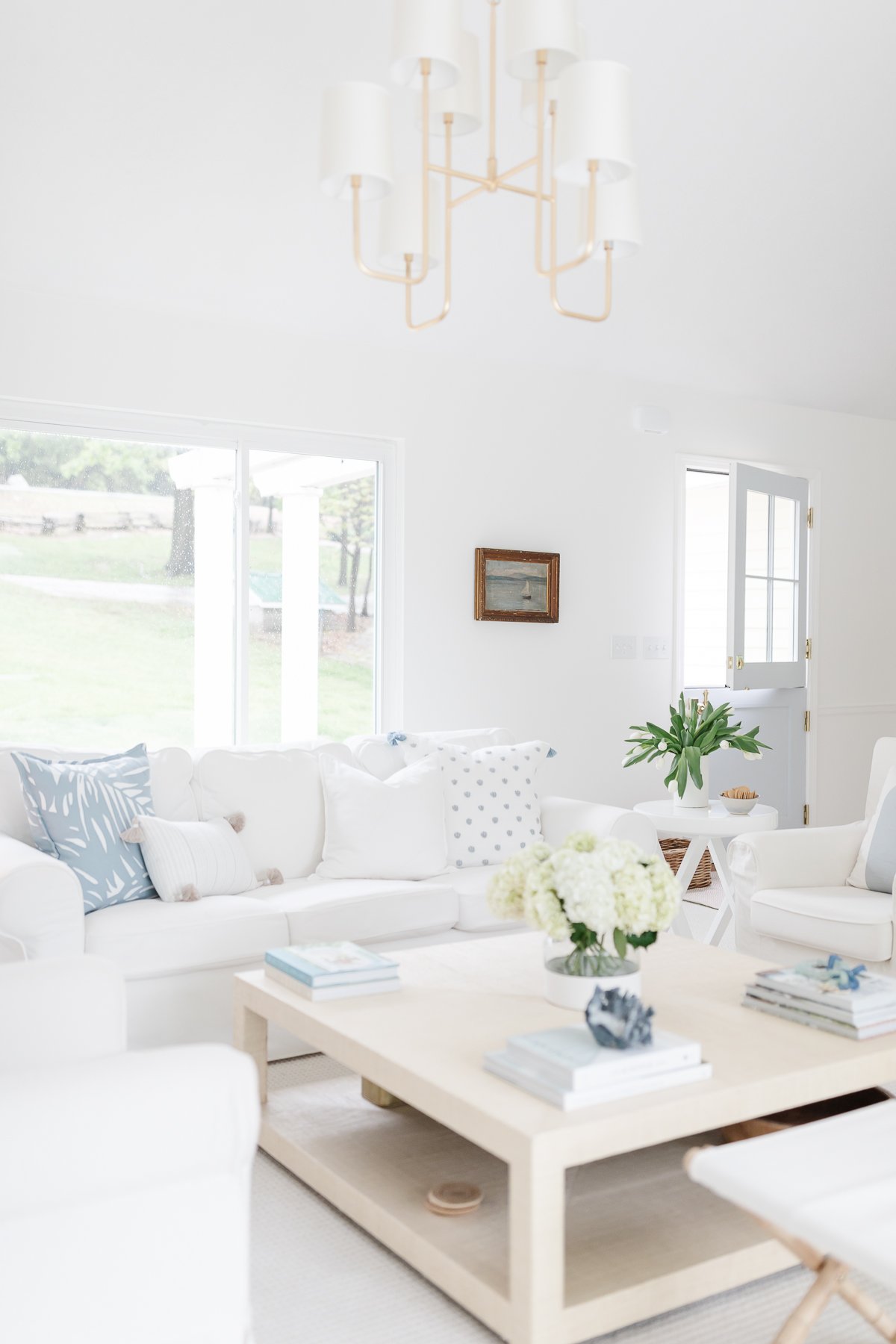 A white living room with blue accents in a guide to minimalist lifestyle.