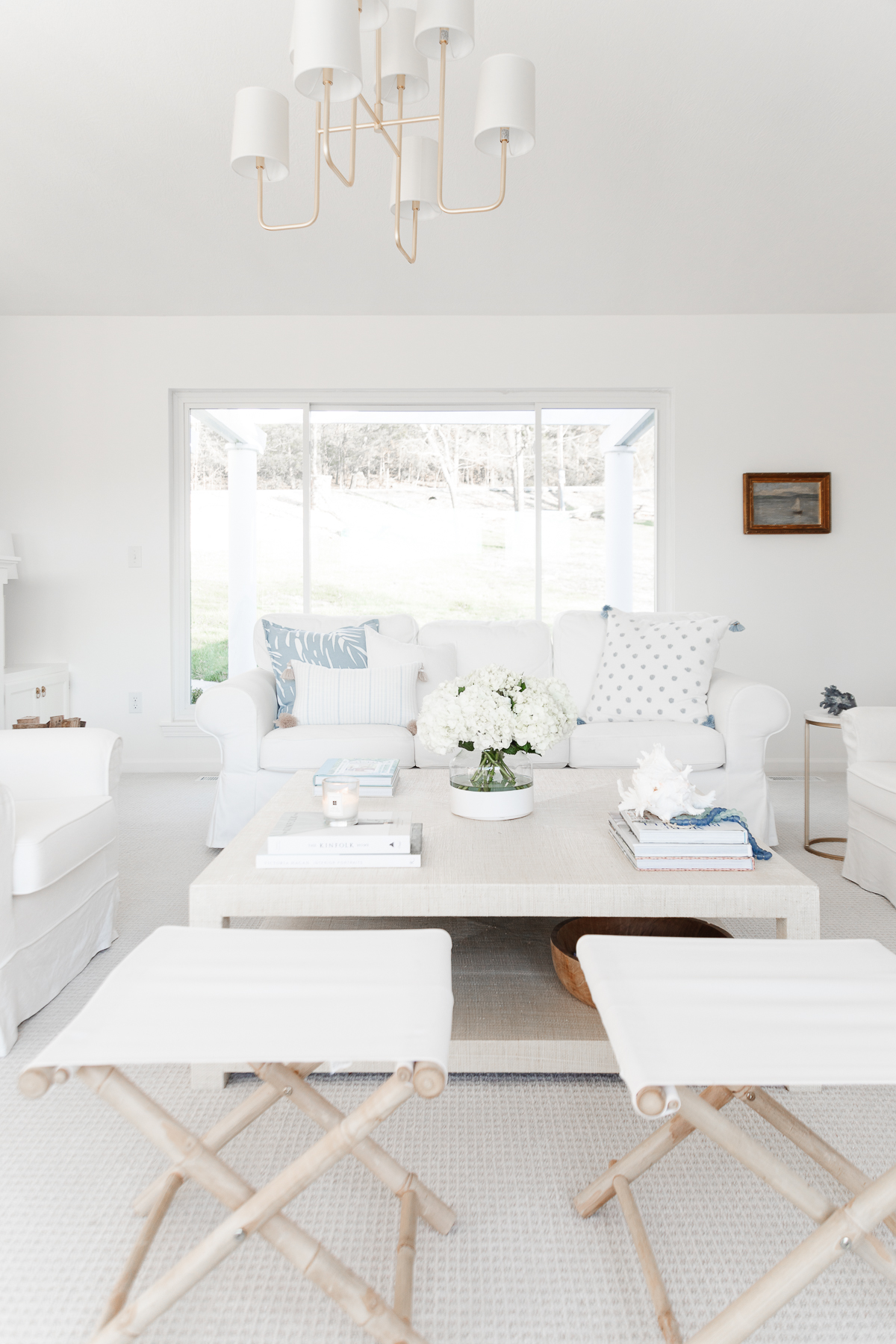 A white living room with blue accents in a guide to minimalist lifestyle.