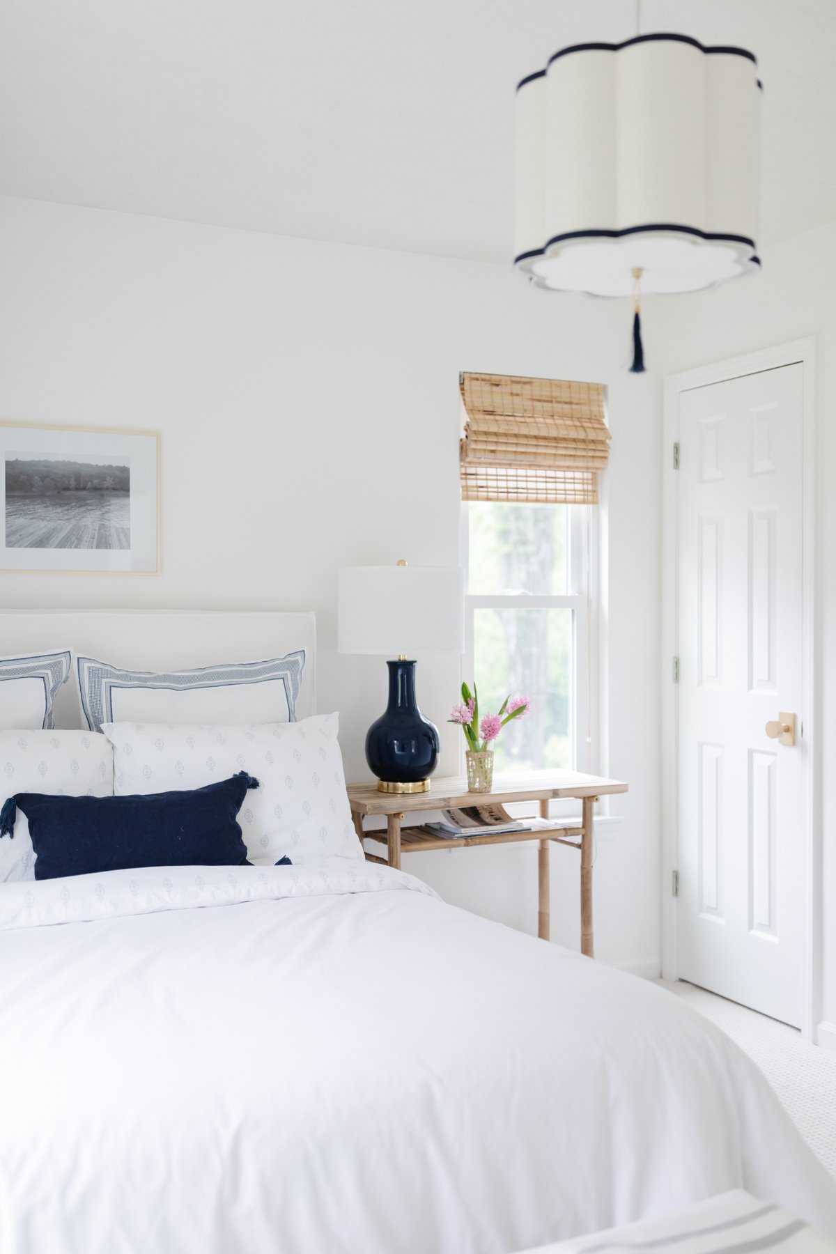 A simple guest bedroom in white and navy in a guide to minimalist lifestyle.