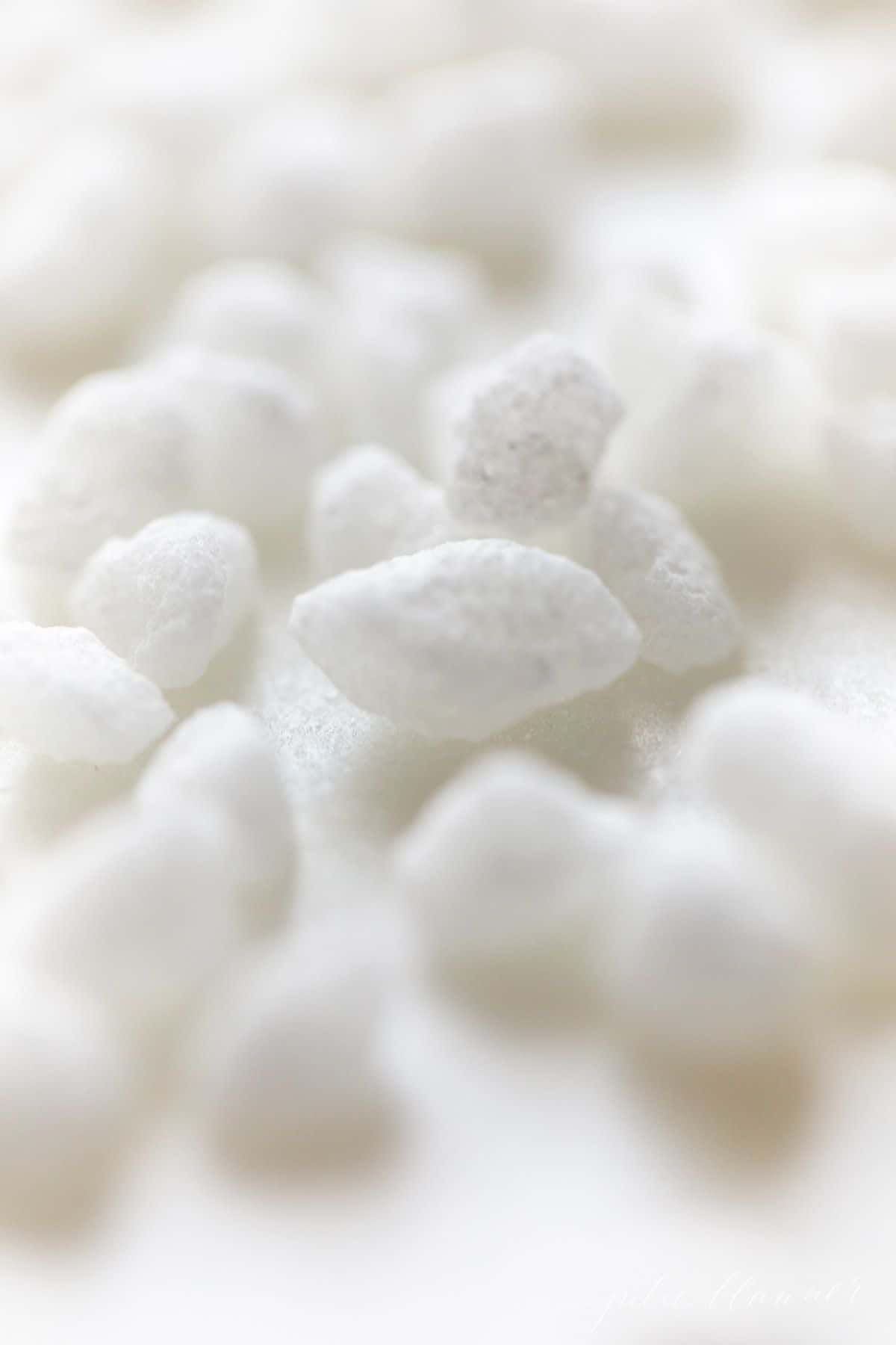 Swedish pearl sugar nibs scattered on a white surface.