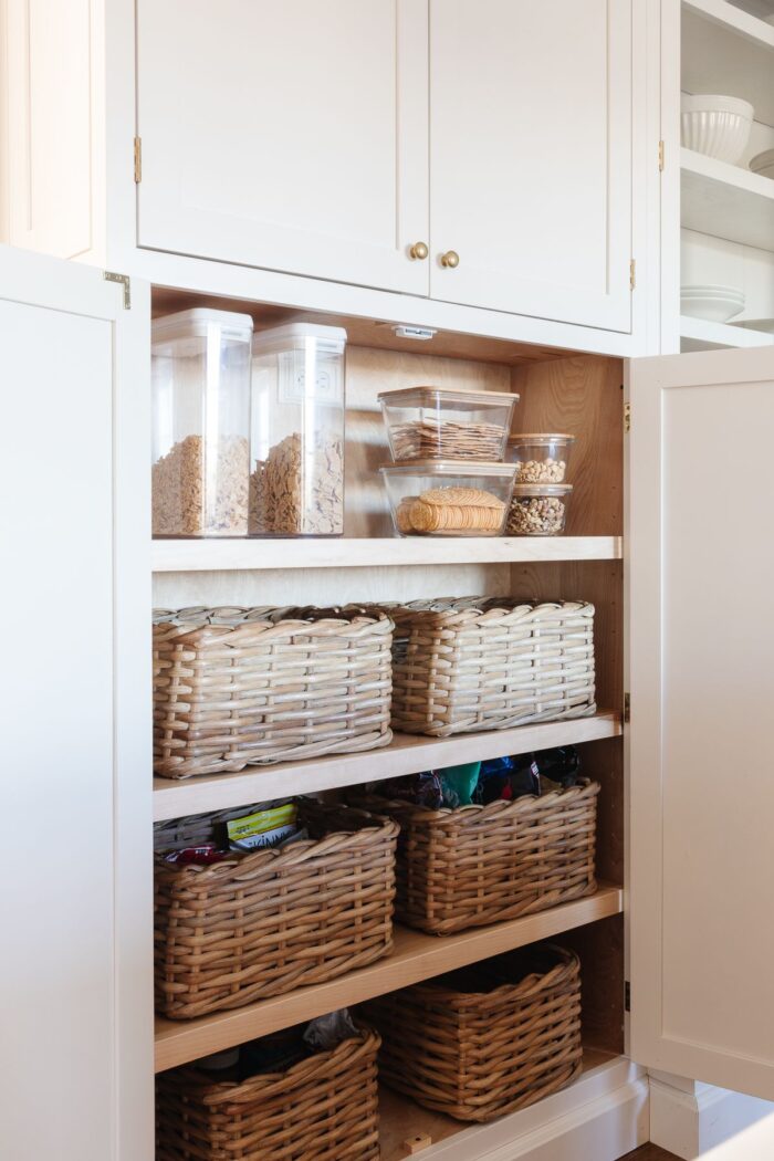 The inside of a pantry cabinet organized with baskets
