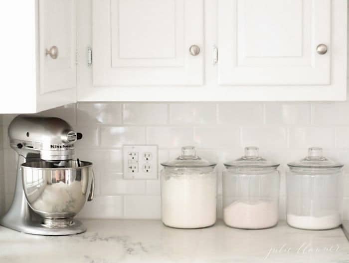 A white kitchen with white subway tile backsplash.