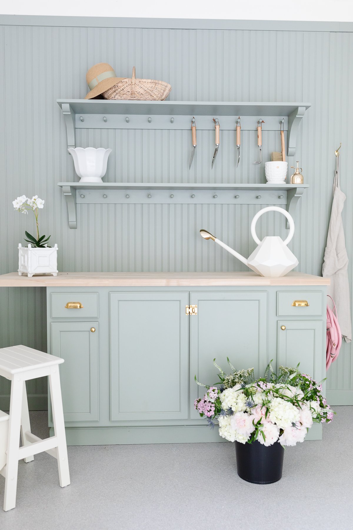 A green potting bench area with beadboard on the walls