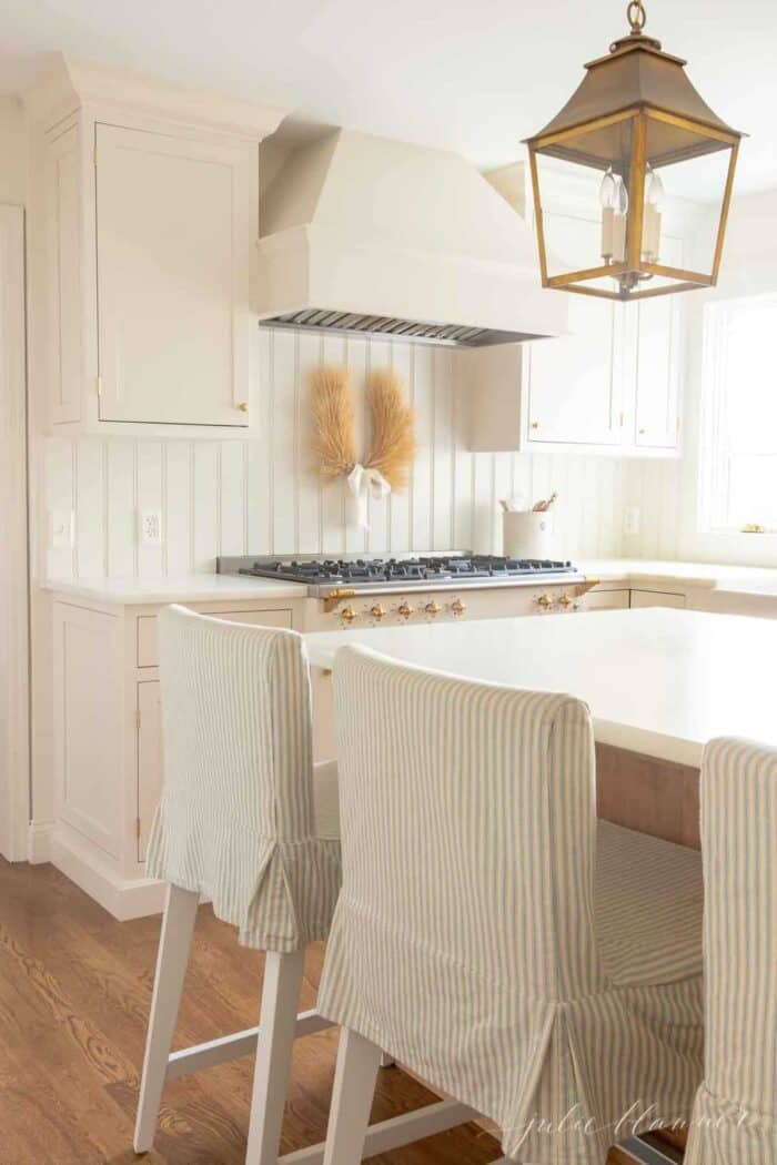 A white and wood kitchen with an marble eased edge countertop
