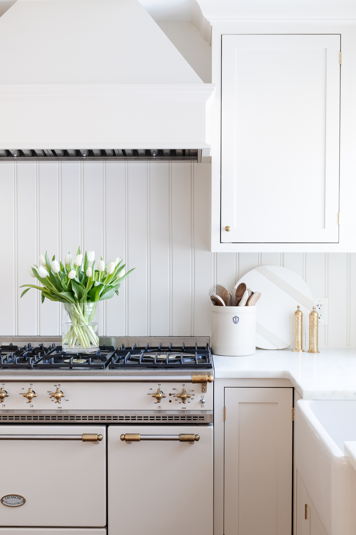 A white kitchen with a beadboard backsplash