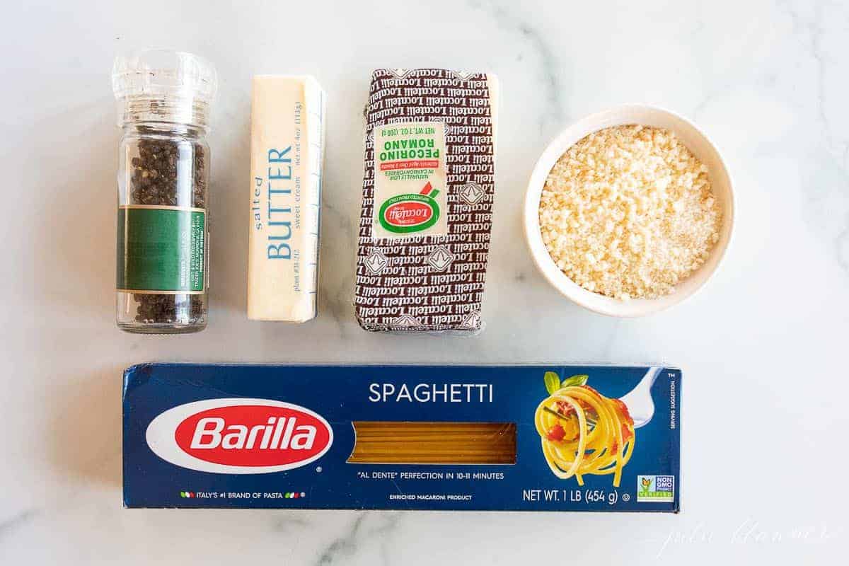 Ingredients for cacio e pepe laid out on a marble surface.
