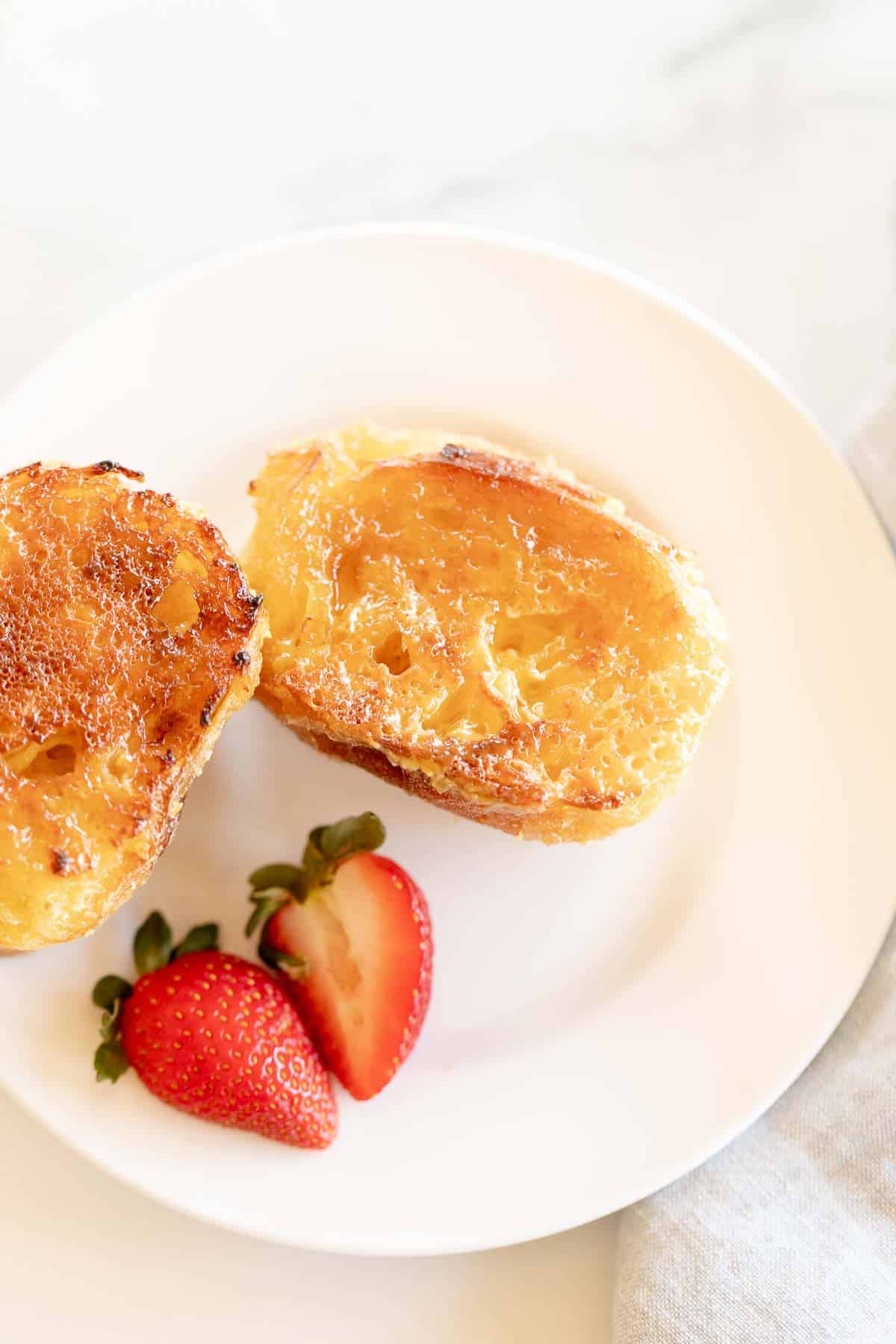 Crème Brûlée French Toast served with strawberries and gold fork