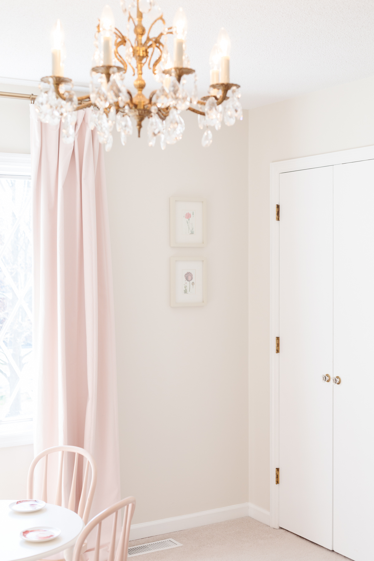 A pink bedroom with an eggshell painted chandelier.