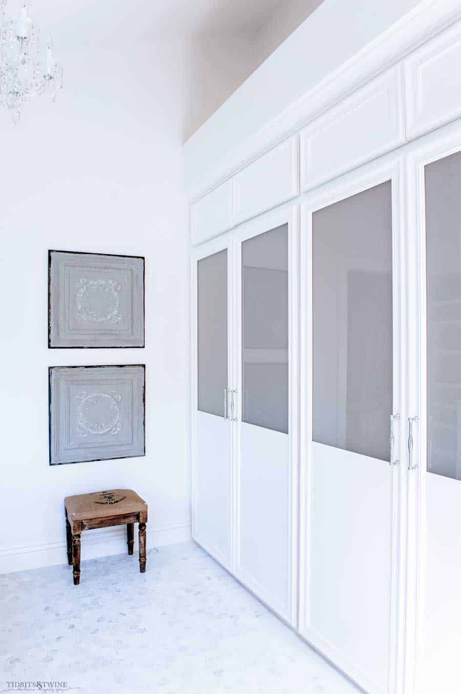 A white hexagon floor tile in a bathroom with frosted glass closet doors.