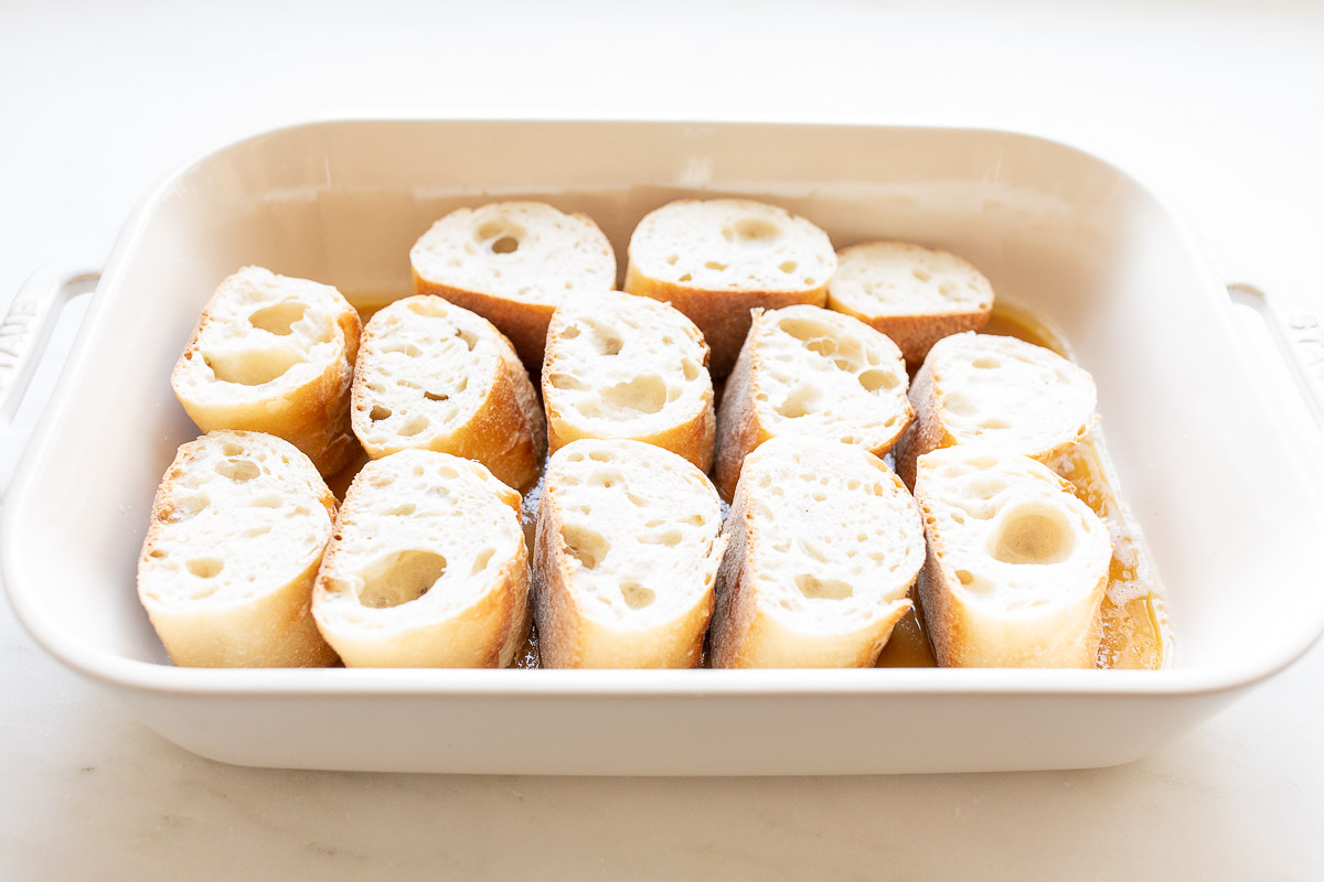 creme brulee french toast casserole in a white baking dish before baking.