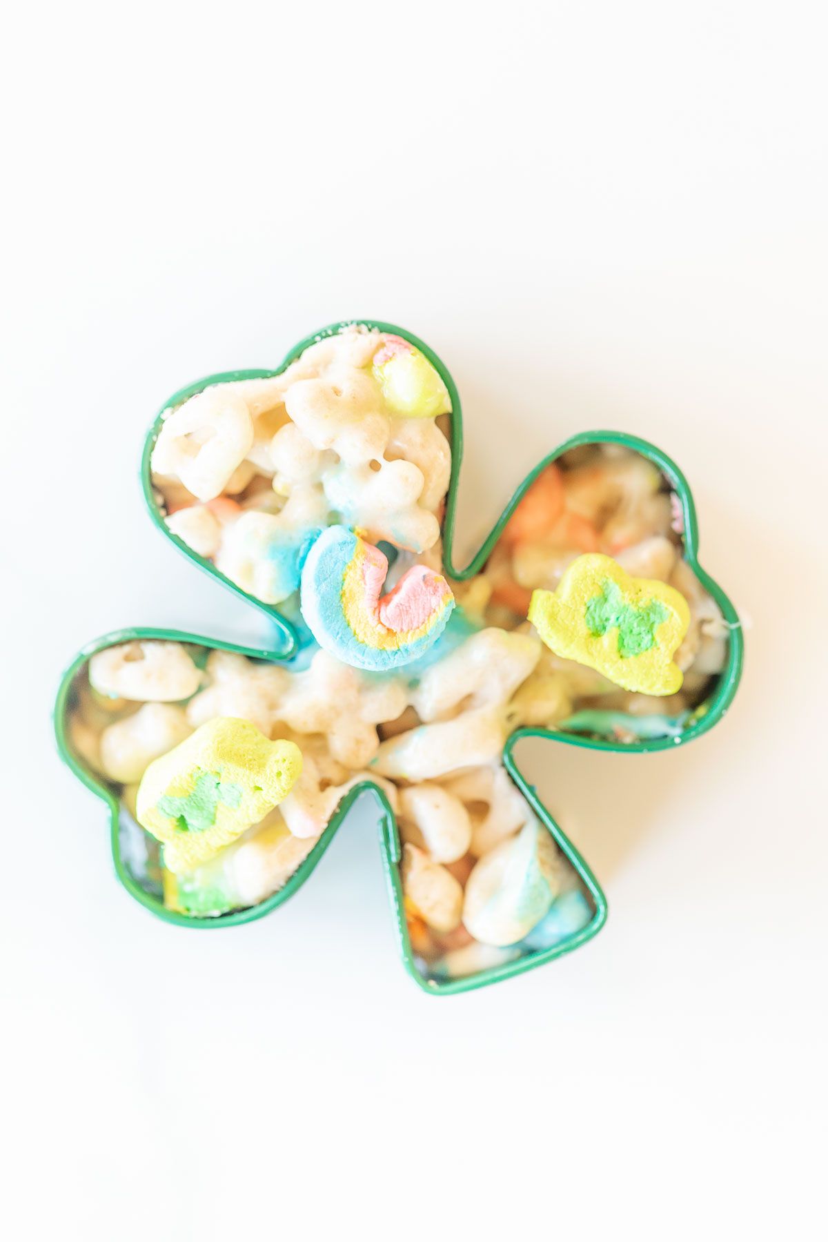 Lucky charm bars cut into clovers and placed on a marble countertop.