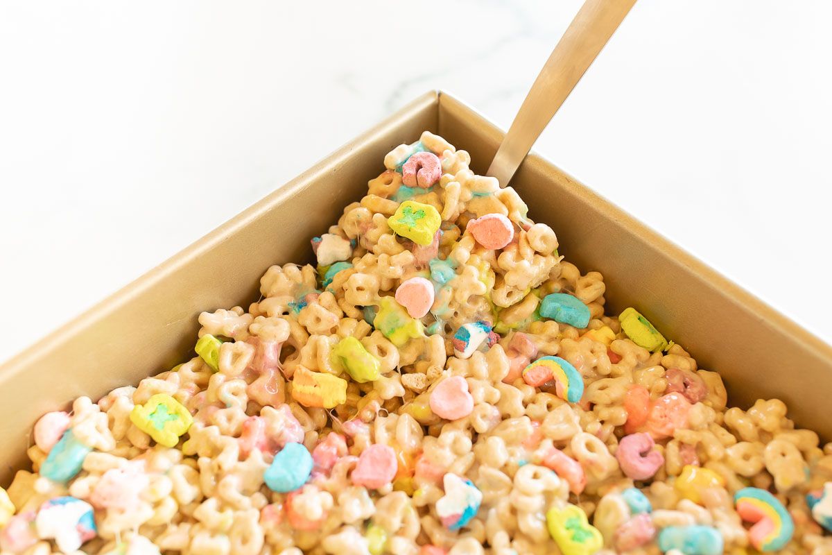 a gold baking pan filled with no bake lucky charms bars.