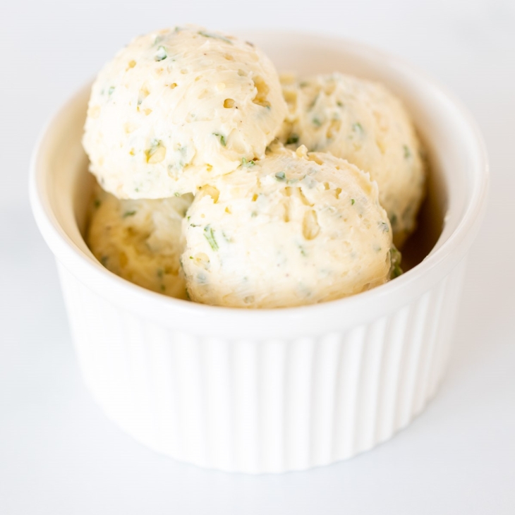 Scoops of herbed steak butter inside a white bowl.