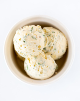 Scoops of herbed steak butter inside a white bowl.