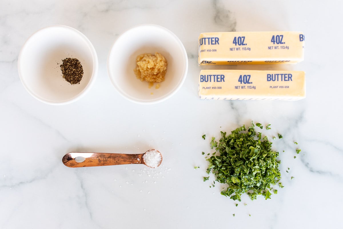 Ingredients for steak butter laid out on a marble countertop.