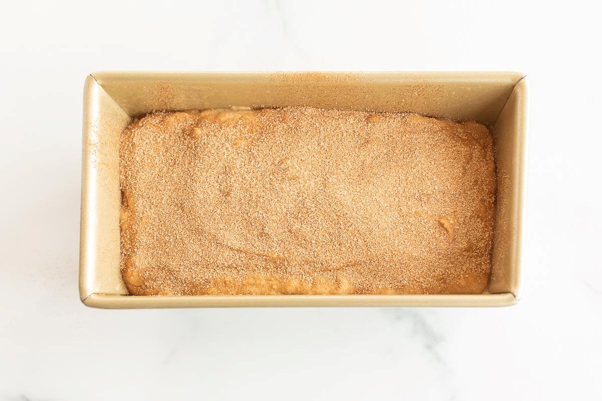 Banana bread batter in a gold loaf pan