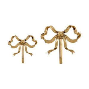 Two gold bows on a white background in a tween girl bedroom.