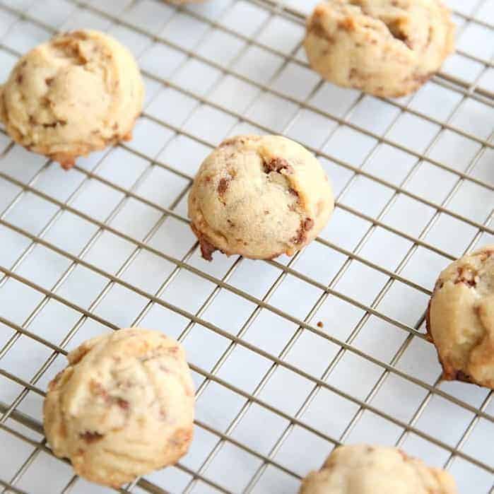 Butter toffee cookies spread out on a wire cooling rack.