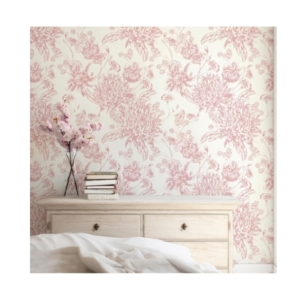 A coquettish bedroom with pink floral wallpaper and a dresser.