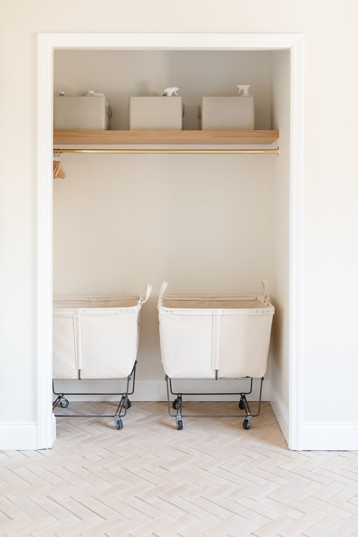 The closet of a modern laundry room with rolling laundry baskets