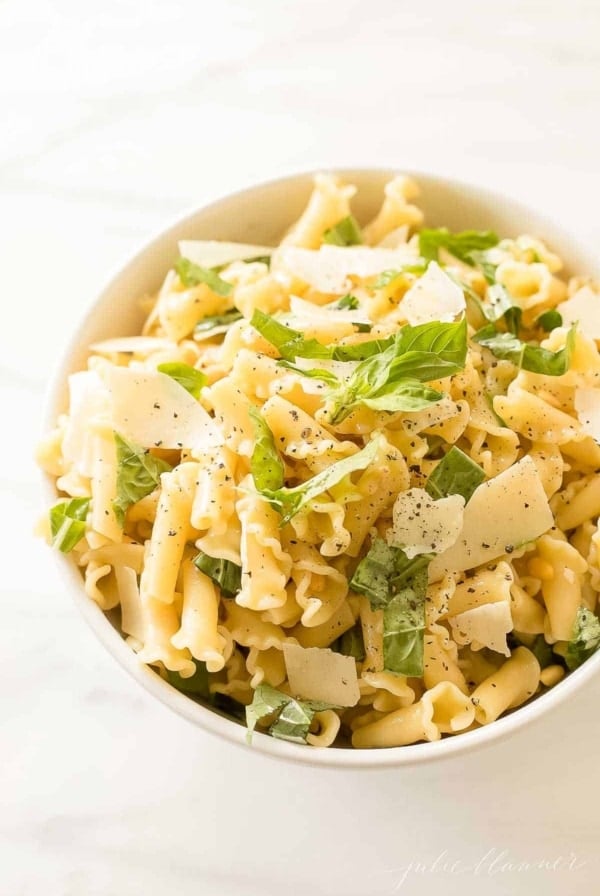 pasta salad topped with basil parmesan and pine nuts
