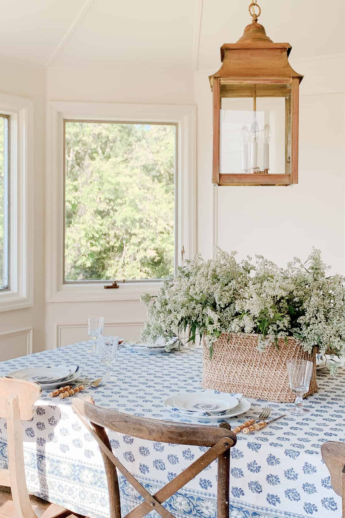 breakfast room with basket of flowers and block print table cloth